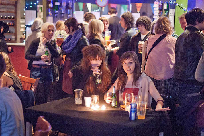 crowd of people drinking in a bar setting