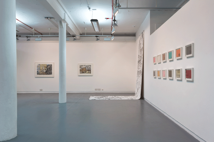 a gallery with drawings hung on the walls