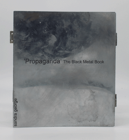 image of a book titled 'propaganda' the black metal book. on the left edge of the book it reads Sandra George.