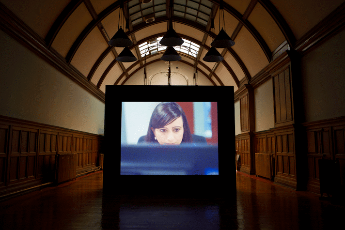 a person looks at a computer screen in a projected film