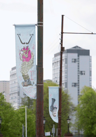 Lamp post banners with street view behind. Banners show graphic image derived from coffee company's logo