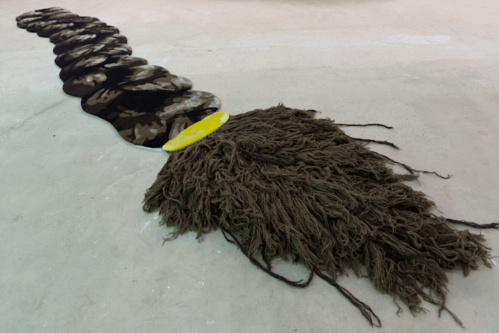 a large scale floor work mimicking a rug and depicting an oversized braid