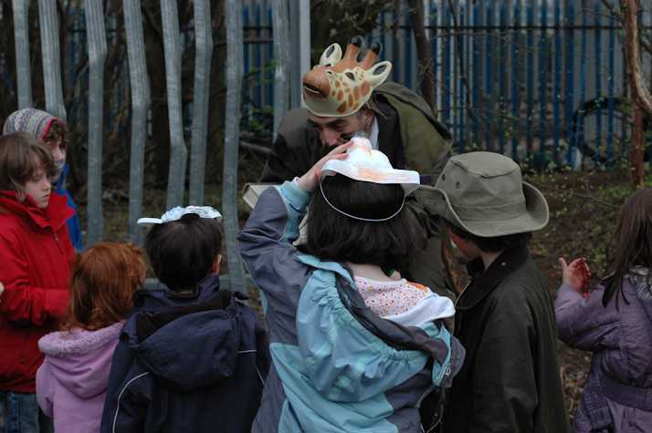 group of children huddled wearing animal masks