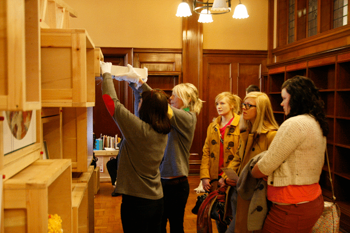 group of people taking objects from a shelf