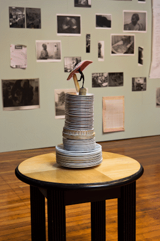 A pile of vintage-seeming plates are stacked on a circular table