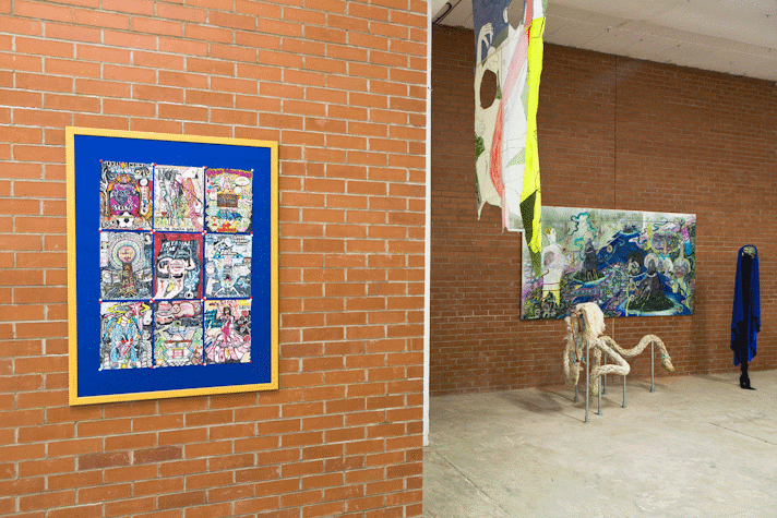 From a distance there are 9 highly detailed felt tip pen drawings pinned to a blue board with gold frame. It is hung on a red brick wall in an industrial space.