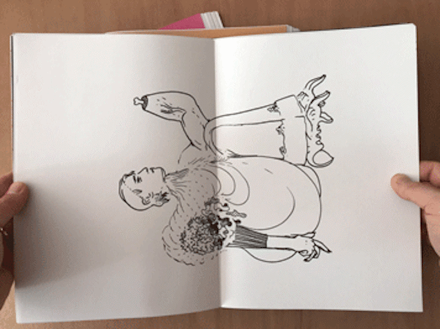 hands hold open an A5 booklet with a double page spread of a black line drawing of a surreal cartoon figure