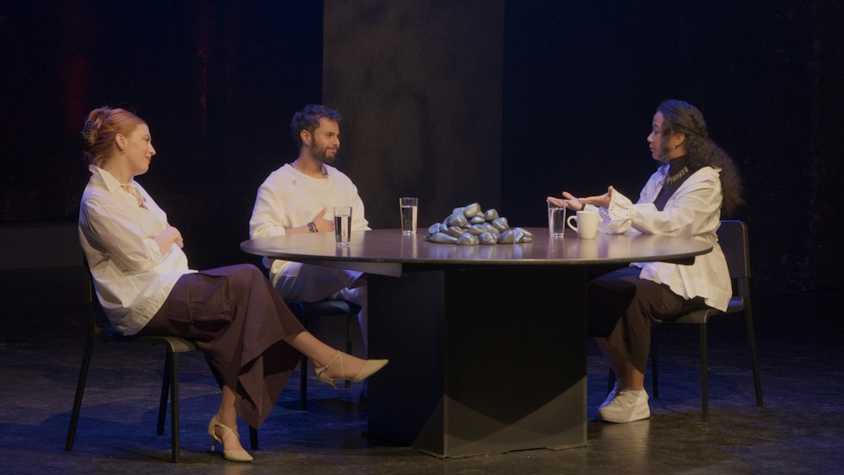 three people sat talking at a roundtable