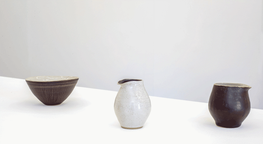 Three ceramic bowls, all different shapes are placed on a plain surface.
