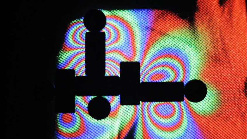 Dark figures in contrast with holographic colorful effects.