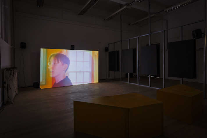 There is a bright screen in a dark room, with film projected onto it.