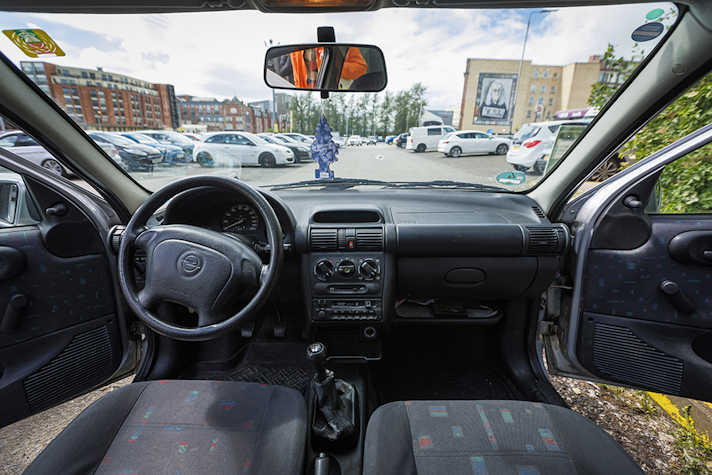 The inside view of a parked car in a car park.
