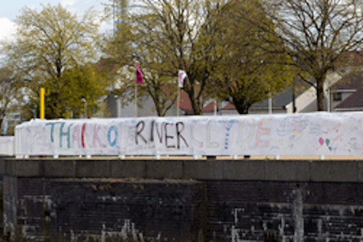 large hand drawn banner stretching across the river bank reading 'thank you river clyde'