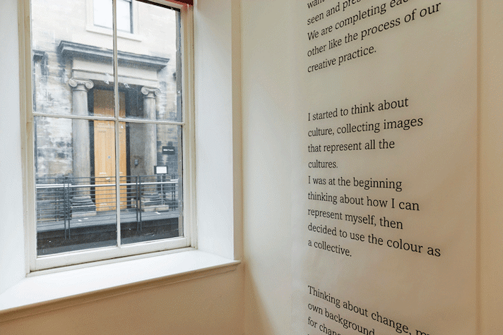 Artwork featuring black and white type is displayed on a wall.