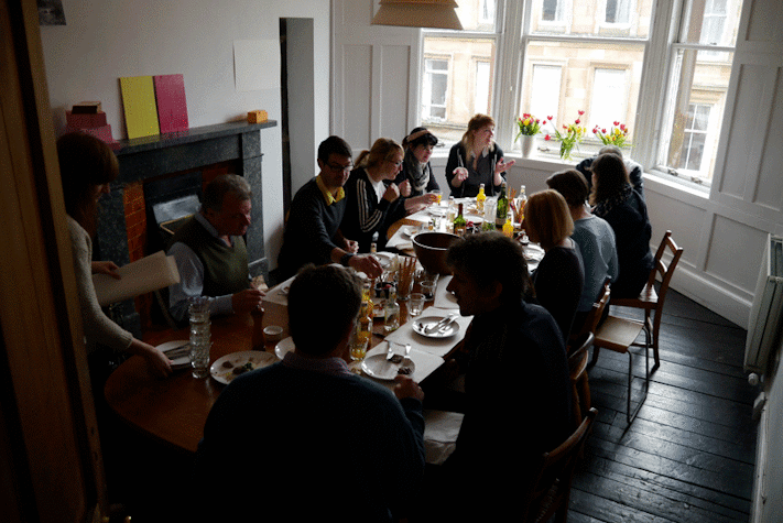 people around a dining table eating and talking