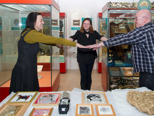 Three people forming a triangle at an exhibition