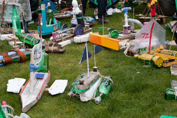 large collection of toy boats made from bottles on grass