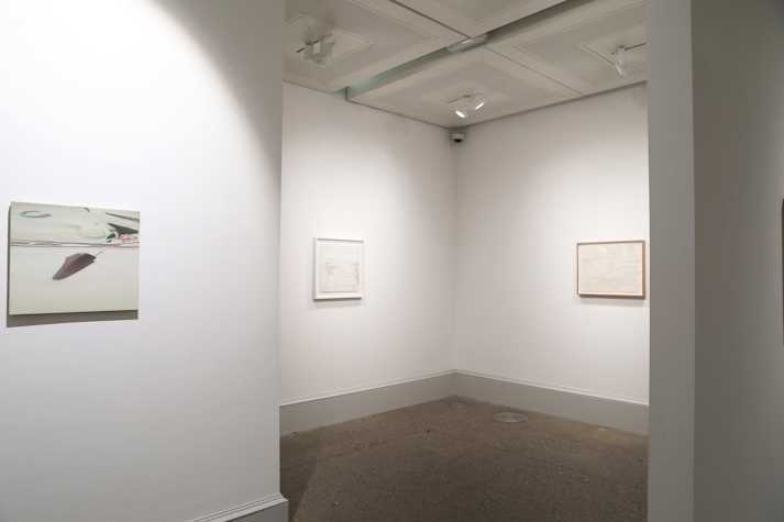 An oil painting and two pencil drawings hang in a white walled gallery