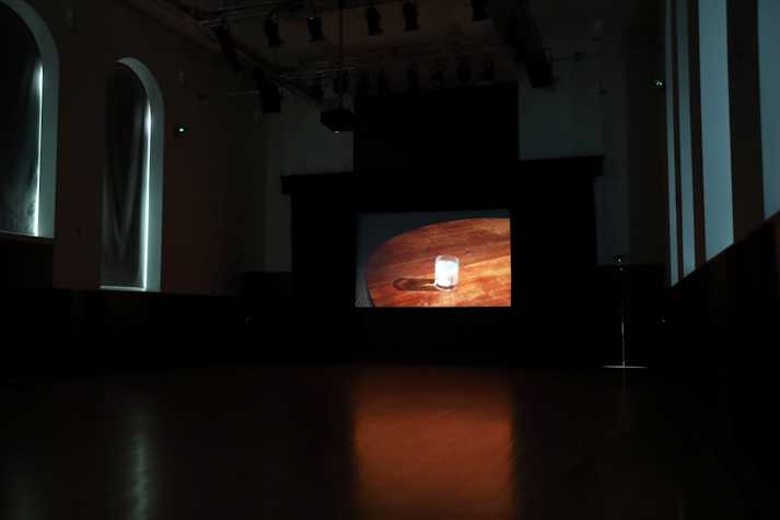 Screen showing image of film with a glass on a wooden table