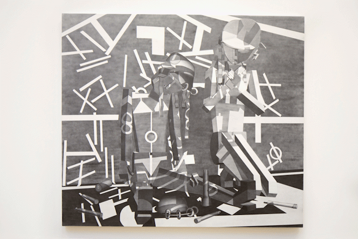 On a wall there is a monochromatic artwork, showing two human like figures. One human figure seems to be a woman sitting down on the ground, the other is a man kneeling next to her with his hands to his chest. There are different geometric shapes scattered all over the painting.