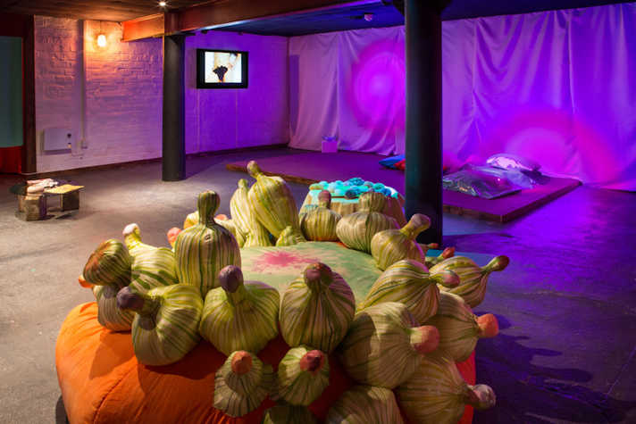 An exhibition space with large sculptural work in foreground, and other work visible in the back ground