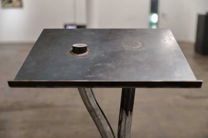 A close up of the top panel of a metal lectern, which has a small metal ring placed on it.