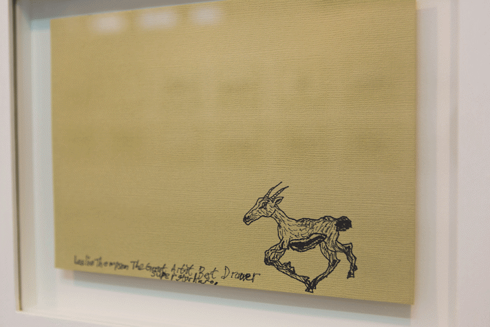 a yellow canvas with black pen drawing of a deer running across it