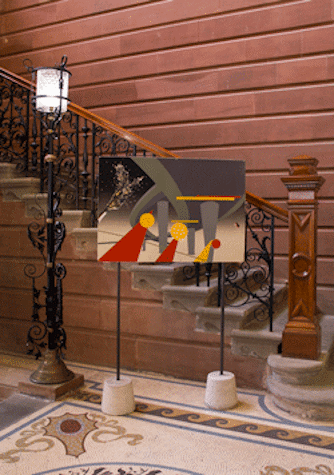 Next to a black small street light and in front of some stairs going up we see a painting sustained by two sticks. The painting is abstract but shows a champagne bottle opened and grey, red and white geometrical shapes. The floor is mosaic and the wall behind is brown.
