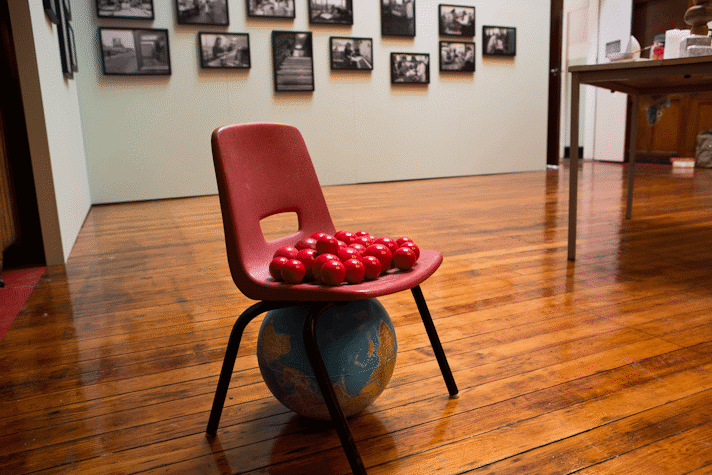 red balls on an red plastic chair, a globe underneath the chair