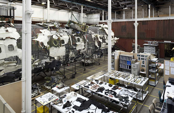 An interior view of Tramway 2 with the frame of a wrecked aircraft with tables of wreckage materials laid out in the foreground