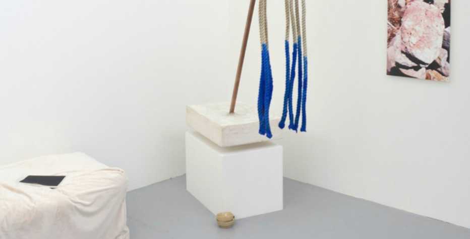 White walled exhibition space with a number of sculptural works visible
