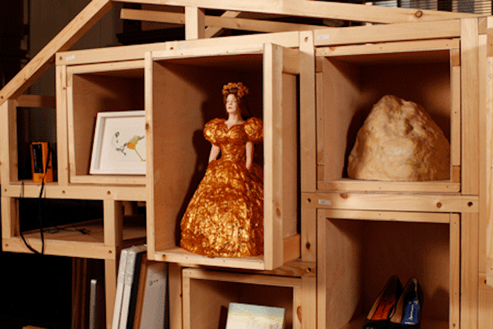 various art works and art objects on wooden shelving