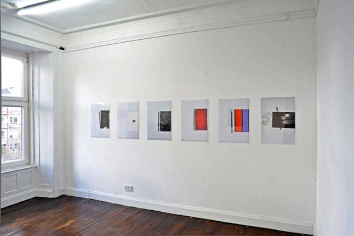 6 prints arranged horizontally on white wall.