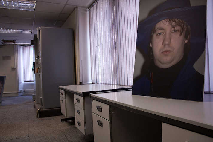 close up portrait photo of someone on a desk leaning against a window. the space is office-like