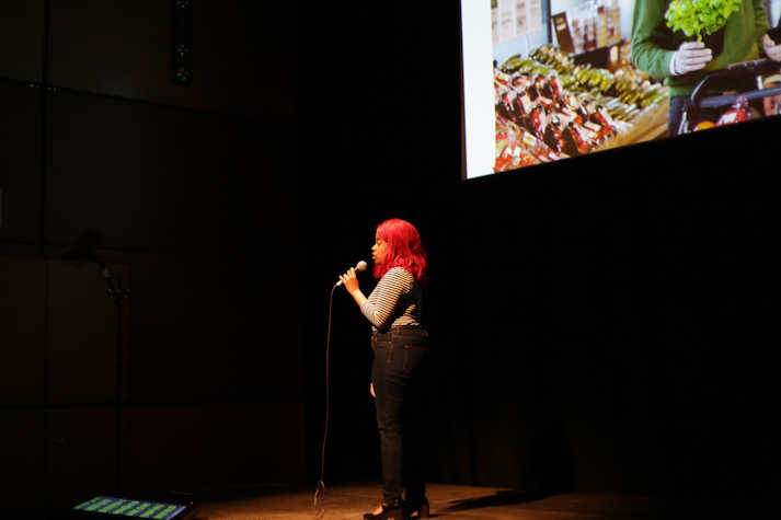 Nostalgia - CCA artist in front of large screen delivering a spoken performance