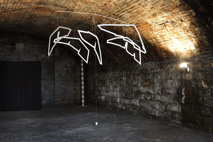 Vaulted basement with suspended neon sculpture