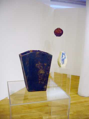 three ceramic pieces on perspex plants of increasing height