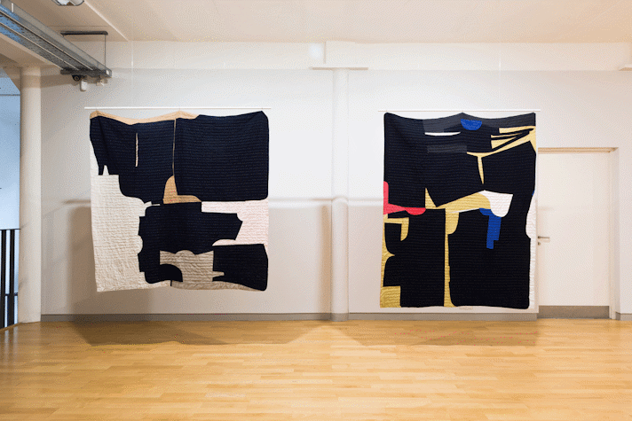 installation view image of large scale quilt hangings with abstract cut out shapes