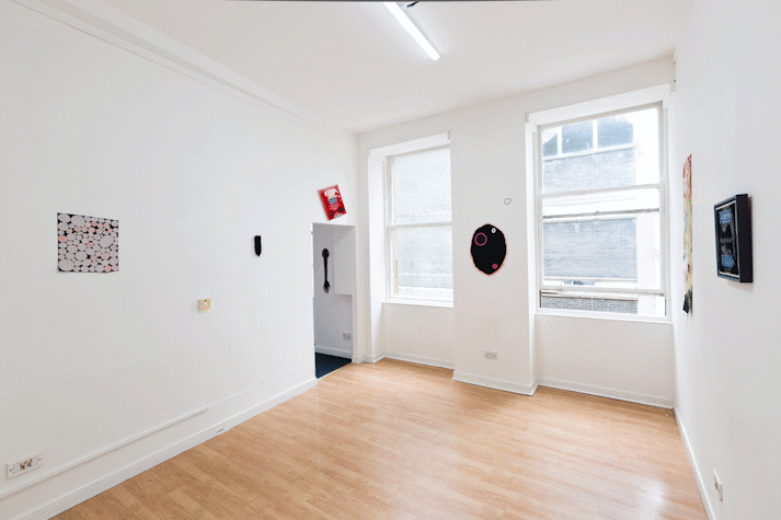 artworks hang on white walls of room
