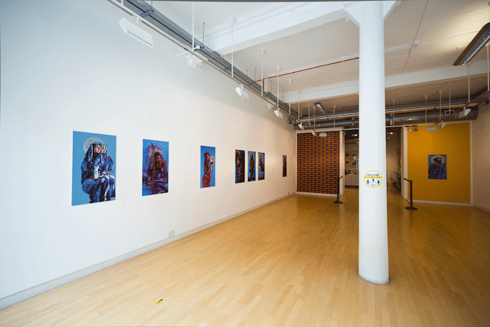 portrait photographs hang in a large gallery room