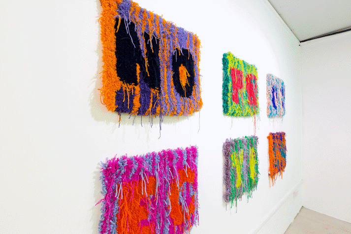 Image of six small multi-colour rectangular carpets in a grid of two rows of three. the carpets read the letters 'N, O'; 'P, R'; 'O, T'; 'E, C'; 'T, I'; 'O, N'