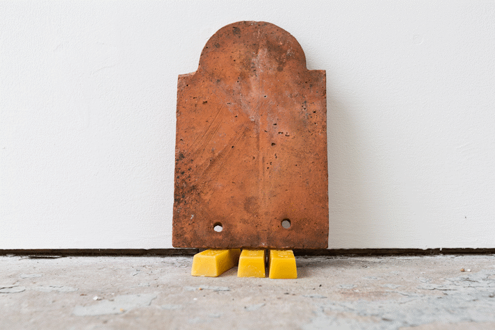 a terracotta tile sits on bars of beeswax