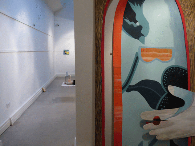 Exhibition view with a coloured sculptural work close up in the foreground, and other works visible in the background