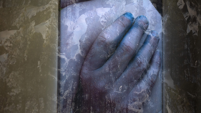 film still of a hand with a double exposure of a snow landscape in the backgroup