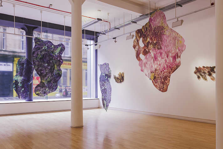 Patterned, colourful shapes hang from the ceiling in a light airy room