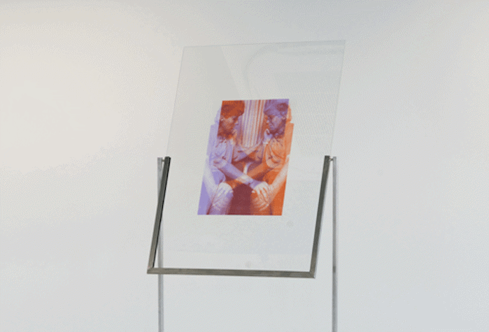 An image showing two people on a transparent surface supported by a bespoke metal stand