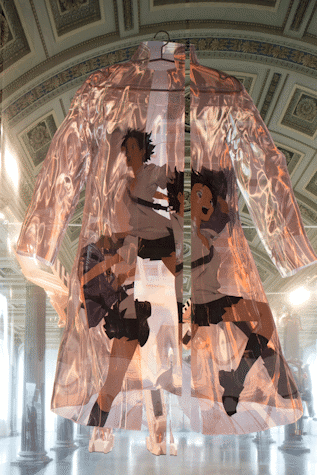 A large reflective, plastic coat hanging off a hanger is printed on polyester foil panels, with laser printed coloured animated figures of three school girls.