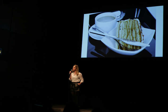 Nostalgia - CCA, artist in front of a large screen delivering a spoken performance