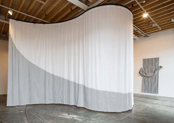 White and gray curtain in a wavy shape as a part of Art installation in Tramway as part of Glasgow International 2018.as a part of art installation in Tramway as part of Glasgow International 2018.