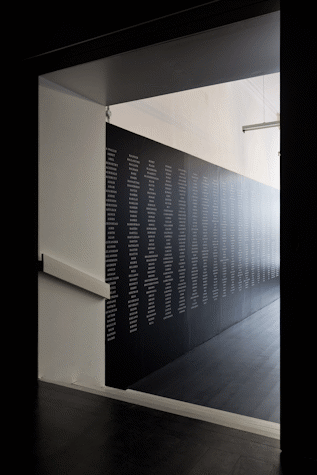 a long black wall with columns of white text